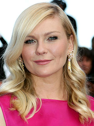 Kirsten Dunst con pintalabios rosa, a juego con su vestido y muy favorecedor.