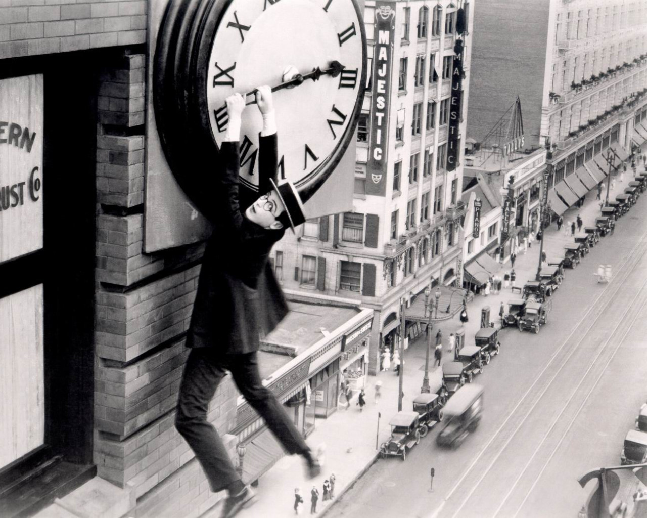 Hombre colgado de las agujas de un reloj en un edificio