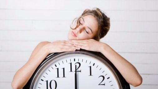 Mujer dormida sobre reloj